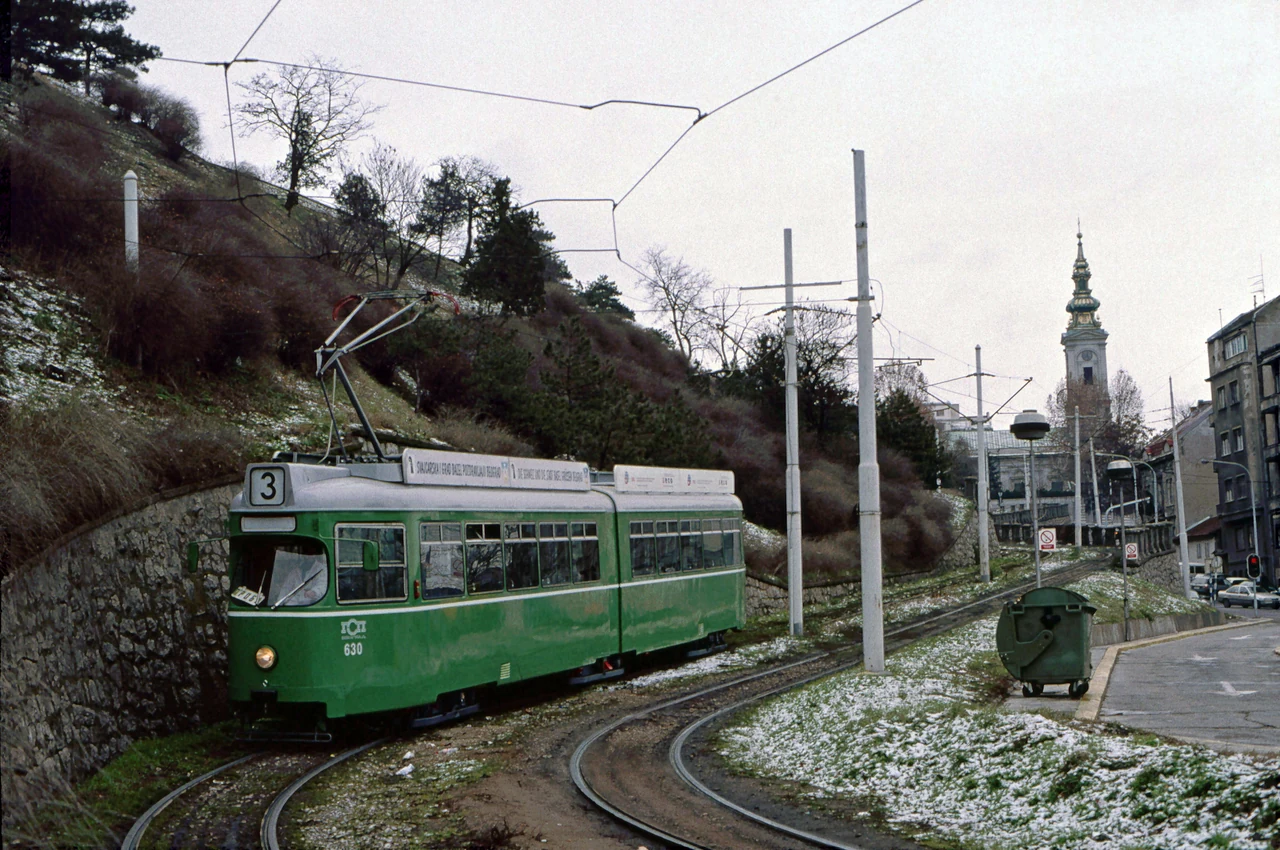 Tram tracks beside a green slope.